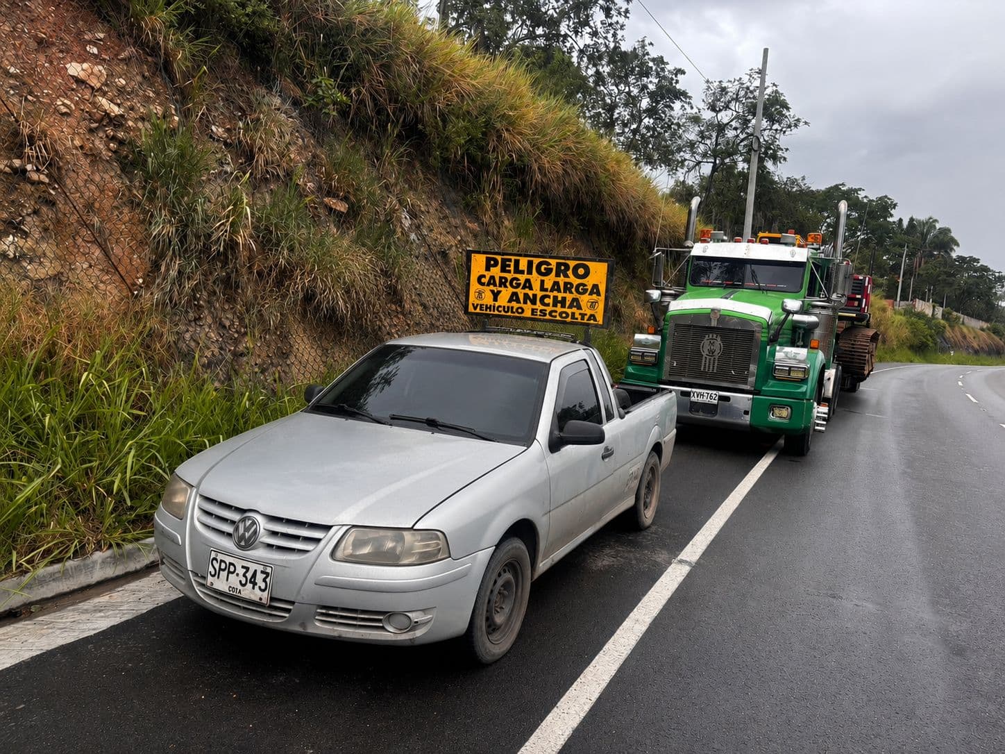 Vehículo escolta con aviso de carga larga acompañando una tractomula
